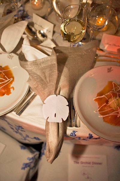 A beachy look by Barclay Butera included sand dollar decorations on napkin rings.