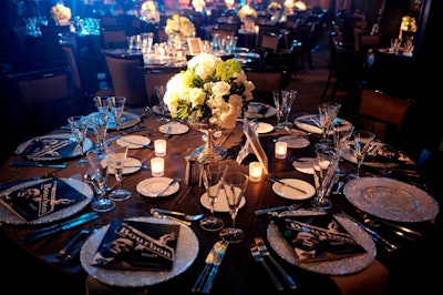 Silver footed bowls filled with white roses and hydrangeas topped tables covered in slate grey linens.