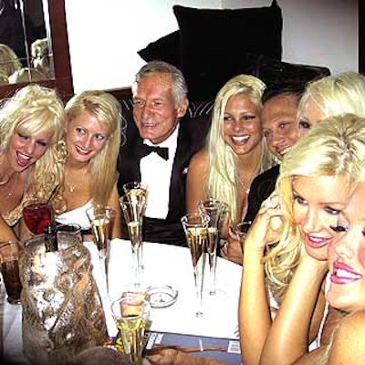 Hugh Hefner and comedian Rob Schneider sat in a booth full of Playboy bunnies at Comedy Central's party following after the Friars Club roast for Hef.