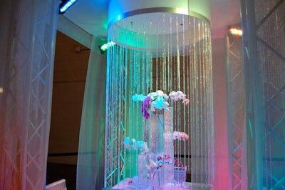 For its Tablescapes display, M&M the Special Events Company used strands of iridescent crystals, multicolored lights, and white and lavender orchids.