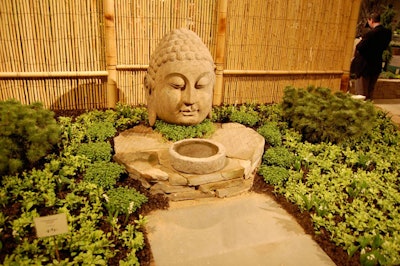 A large Buddha head sits outside the display area dubbed 'Reflections: A Spirited Garden of Asian Inspiration.'