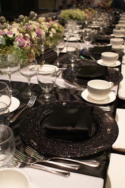 Event designers used solid black and white place settings with simple silver flatware.