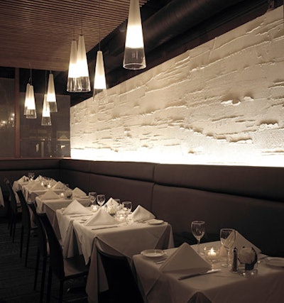 A textured white wall, banquettes, and Italian leather seating fill the dining room.