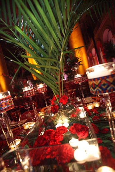 Red carnations and tea lights floated in water-filled glass vases.