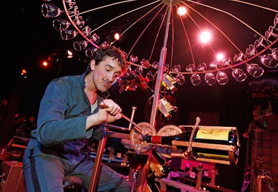 A Redmoon actor poured drinks from his perch atop the theater's wine bike—a machine with an umbrella of rotating glasses.