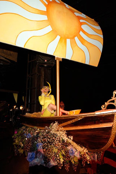 A performer dressed in yellow snorkel gear sat in a grape-strewn boat and mimed chatting on the phone.