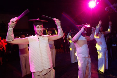 A procession of performers marched through the crowd, keeping time on drums that were affixed to their heads.