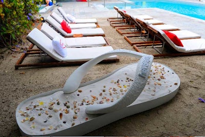 An oversize Havaiana prop filled with sand and seashells added to the branded ambiance.