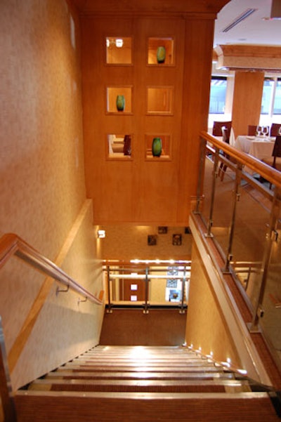 Green vases are displayed in the maple wall unit above the staircase.