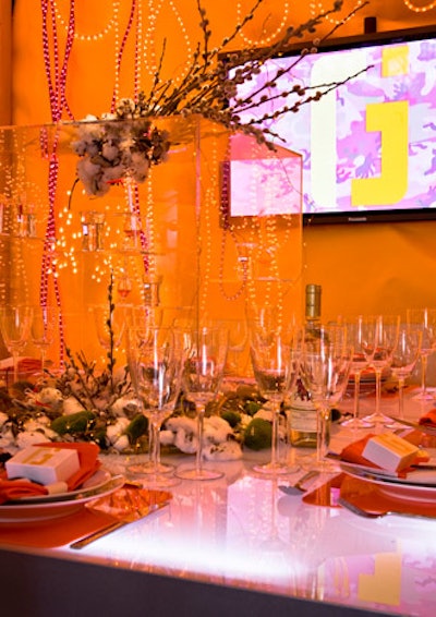 Tube lights surrounded Jes Gordon/ProperFun's table, giving it a golden glow. A Lucite cube filled with little glass birds served as a centerpiece.