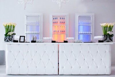 Bartenders poured behind a tufted white bar.