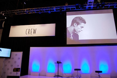 Stylists for American Crew demonstrated new men's hair-cutting techniques against a backdrop of blue lighting.