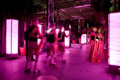 Roller skating entertainers draped in hot-pink feather boas served drinks.