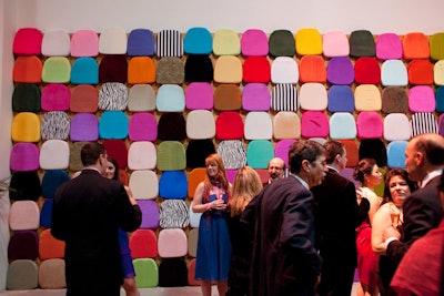 Volunteers arranged chair cushions on a wall in the cocktail space.