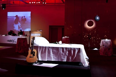 Red lighting filled Baillie Court, where actors dressed as John Lennon and Yoko Ono lay on a bed placed atop a riser in the centre of the room.