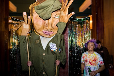 A performer dressed in a larger-than-life paper mâché puppet costume moved through the crowd all evening.