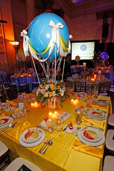 Model hot-air balloons floated above tables covered in bright yellow and blue linens.