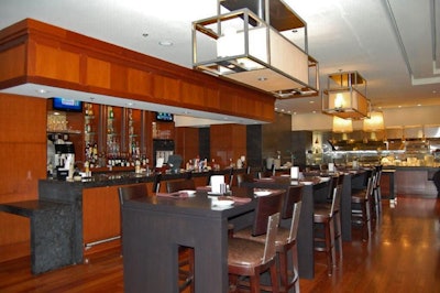 The restaurant's central section has an eight-seat black granite bar, an open kitchen, and a 12-seat communal table.