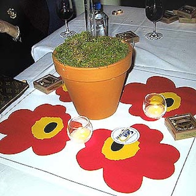 Monroe Alechman of Estee Lauder and DeVinn Bruce of DeVinn Visuals designed centerpieces with pink daisy-decorated mats underneath adobe flower pots filled with moss.