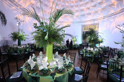 Six-foot-tall centerpieces of ferns, bamboo, and other greenery in thick green cylinders punctuated the jungle-themed Rotunda, where fern-shaped gobos projected onto the ceiling and potted trees dressed up the entrances.