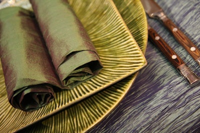 The four settings in the Atrium matched square and round plates. Here, lime and purple linens accented green textured plates and wood-trimmed flatware.