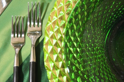 The Rotunda setting complemented the room's jungle motif with gold chargers, green glass dinnerware, and patchwork tablecloths made from recycled linens.