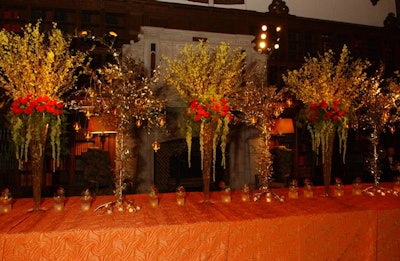 Five-foot-tall metal tree sculptures tied with gold-painted leaves flanked the arrangements.