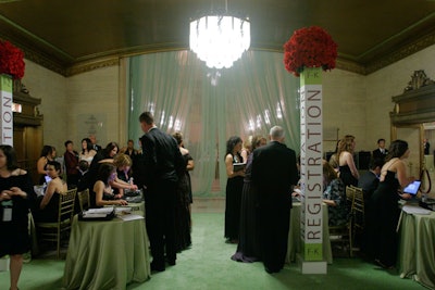 Staffers used computers to check guests in at the registration area, which Kehoe Designs spruced up with red roses and green chiffon draping.