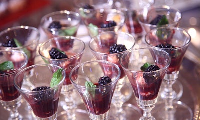 A mint leaf and fresh blackberry garnished a shooter of white chocolate truffle in cherry coulis.