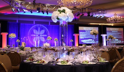 Tall arrangements of white roses, hydrangeas, and tulips topped tables in the ballroom.