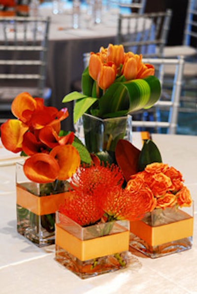 The company used square glass vases filled with orange tulips, roses, and calla lilies and red pincushions accented with orange ribbon and magnolia leaves as centerpieces at the MorseLife Geriatric Symposium in West Palm Beach.