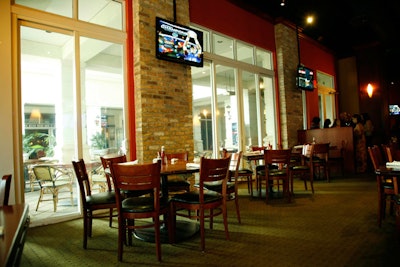 Tall glass doors open onto the covered terrace, which has additional seating for 75.