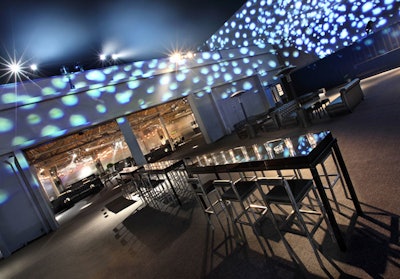 White patterned lighting decorated the walls along the carpeted parking lot.