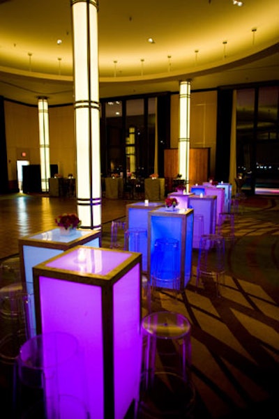 Glowing rectangular tables lit in purple and pink topped with balls of roses decorated the areas in between the dining rooms.