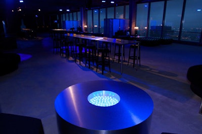 Tall steel tables and stools reflected the front room's blue lighting.