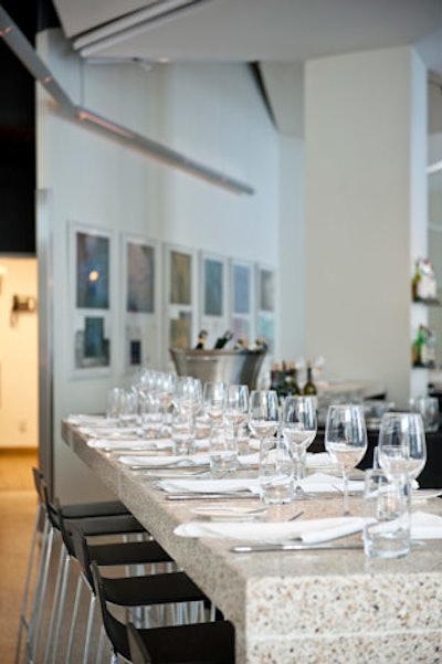 The sleek, minimalist decor is anchored by white terrazzo tile throughout the dining room.