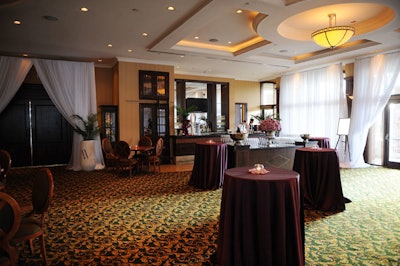 Dark purple linens and votive holders surrounded by rose petals topped tables in the reception area.
