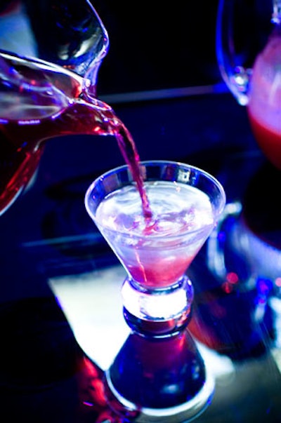 Servers offered cocktails to guests at a square black bar in the centre of the lounge area.