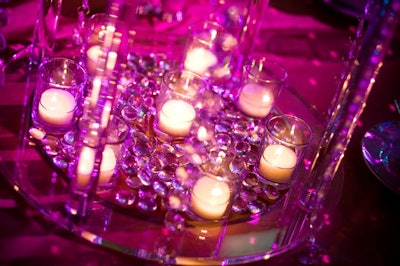 Clear glass pebbles and votive candles filled the base of the centrepieces.