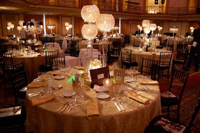 Gold linens, crystal globes, and black Chiavari chairs accented dinner tables.