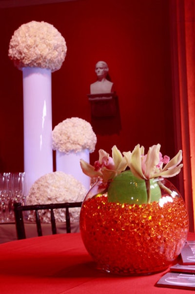 Ball-shaped arrangements of white carnations on glowing cylinders flanked one bar in the Atrium; while globes of orange gel topped with green orchids decked the side tables.