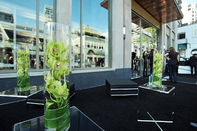 Tall vases filled with green orchids from Events in Bloom topped tables on the patio.