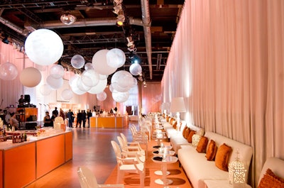 A series of oversize white balloons hung from the ceiling above two orange bars in the Artifacts Room.