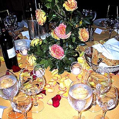 Votive candles were placed on the table among scattered red and yellow rose petals.
