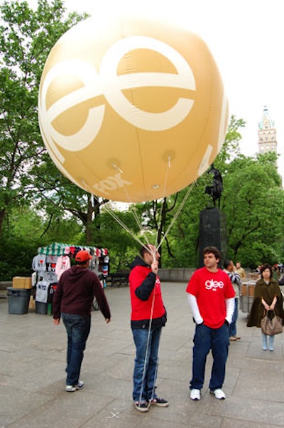 Giant balloons branded with logos for new Fox series Glee paved the way from the City Center to Central Park's Wollman Rink.