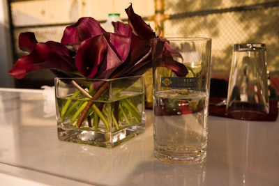 Cocktail tables dressed in burgundy linens and arrangements of calla lilies provided a splash of color on the court.