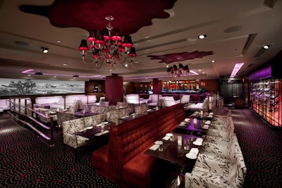 Leather banquettes and crimson chandeliers decorate the dining room.