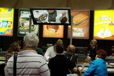 Show attendees lined up to watch candy-making demonstrations and sample new Hershey's products.