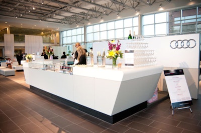 Audi's four-ring logo featured prominently on a backdrop behind the bar.