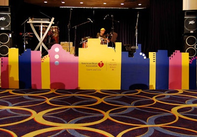 A colorful Art Deco-style wooden skyline cutout adorned the front of the stage.